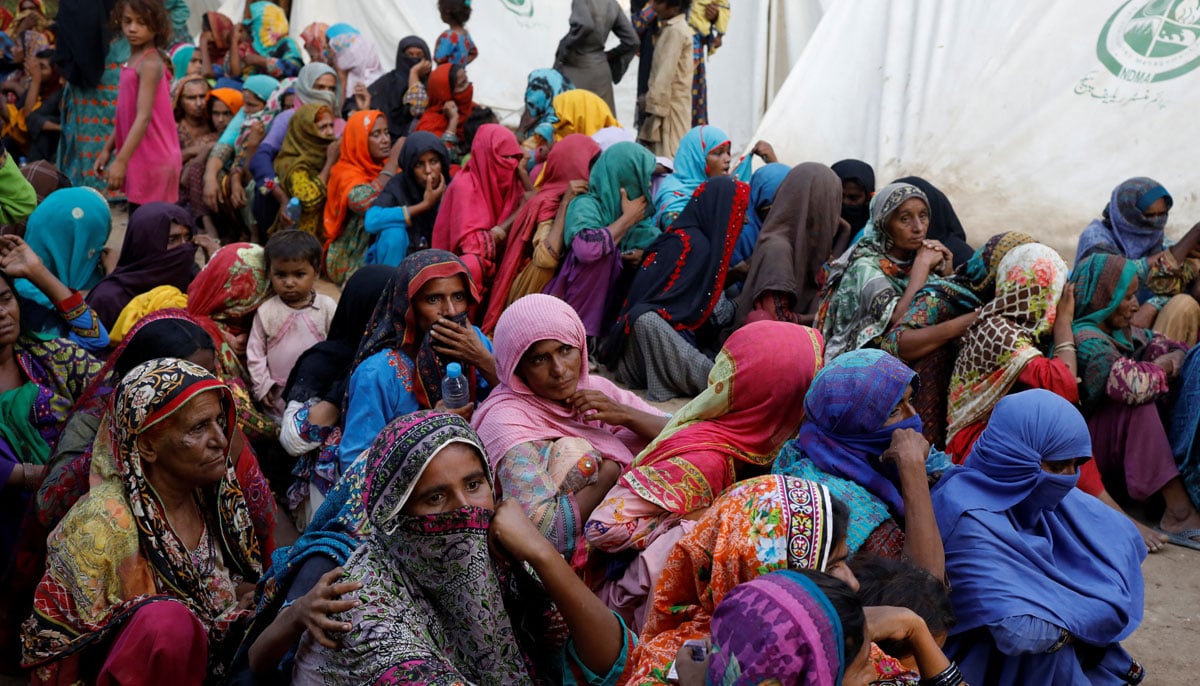 Women displaced because of the floods wait to receive food handouts while taking refuge in a camp, in Sehwan, September 30, 2022. — Reuters