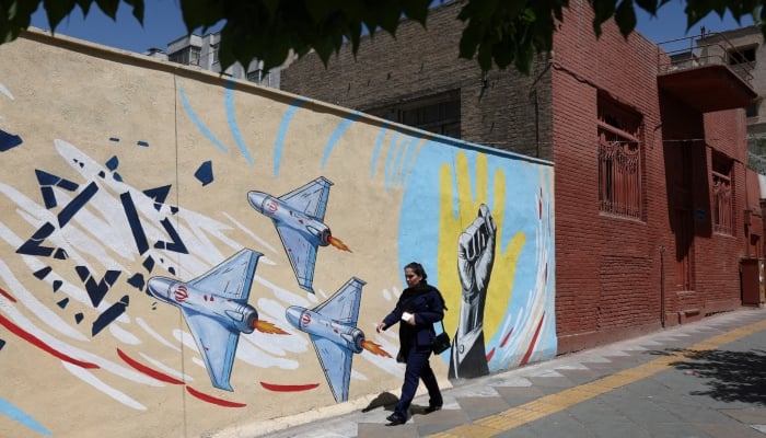 An Iranian woman walks next to an anti-Israeli mural on a street in Tehran, Iran, May 30, 2026. — Reuters