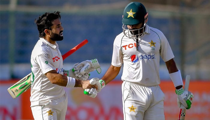 Mohammad Rizwan (L) shakes hands with Babar Azam (R) during a Test match in Karachi. — X/PCB/File