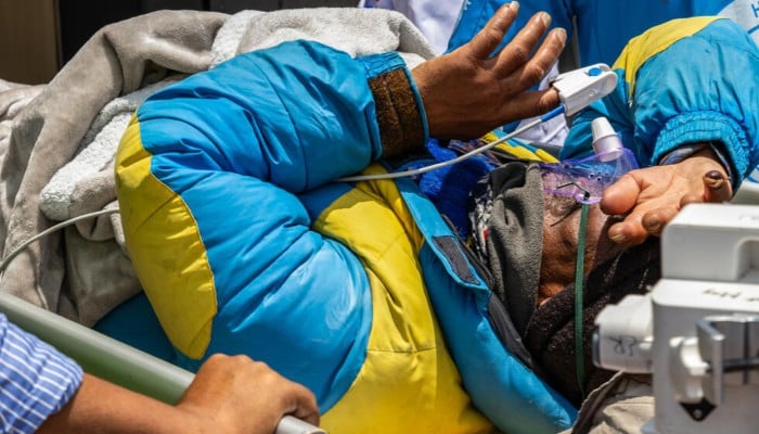 Mountaineer Dawa Sherpa is carried by medics and rescuers upon his arrival at the HAMS Hospital in Kathmandu on June 4, 2026. — AFP
