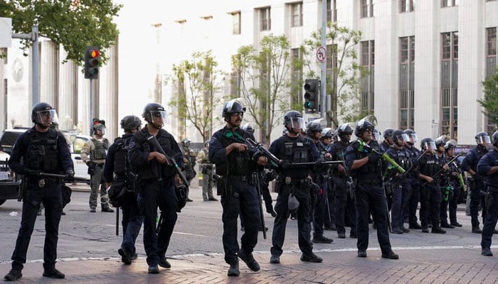 Members of law enforcement stand guard as people protest against federal immigration sweeps, in downtown Los Angeles, California, US. — Reuters/File