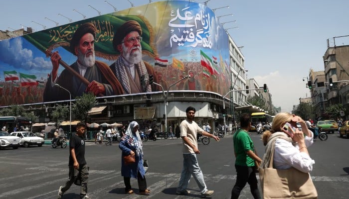 People walk past a billboard depicting the late leader of the Islamic Revolution, Ayatollah Ruhollah Khomeini, and the late Irans Supreme Leader Ayatollah Ali Khamenei, on a street in Tehran, Iran, June 6, 2026. — Reuters