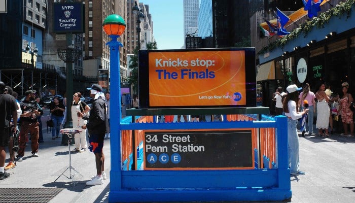 People walk past a New York Knicks-themed 34th Street Penn Station subway entrance on June 04, 2026, in New York City. — AFP