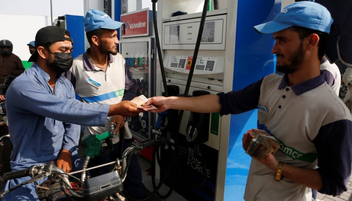 A rider for a delivery platform pays for fuel at a petrol station in Karachi, on March 18, 2026. — Reuters