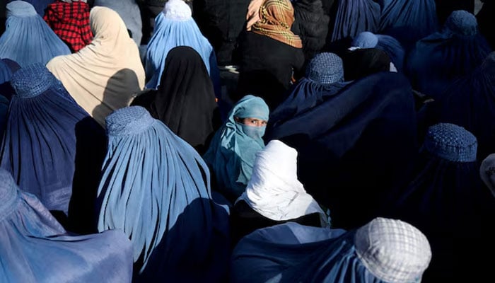 A girl sits in front of a bakery in the crowd with Afghan women waiting to receive bread in Kabul, Afghanistan.— Reuters/File