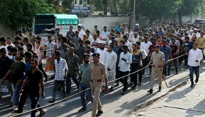 Police officers escort men they believe to be undocumented Bangladeshi nationals after they were detained during raids in Ahmedabad, India on April 26, 2025. — Reuters