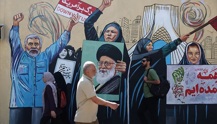 People walk on a street near a mural featuring an image of the late Supreme Leader of Iran, Ayatollah Ali Khamenei, in Tehran, Iran June 8, 2026. — Reuters