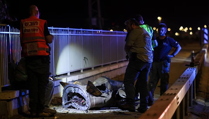 Israeli security and rescue personnel work next to a part of a projectile following a missile attack from Iran towards Israel in northern Israel, June 8, 2026. — Reuters