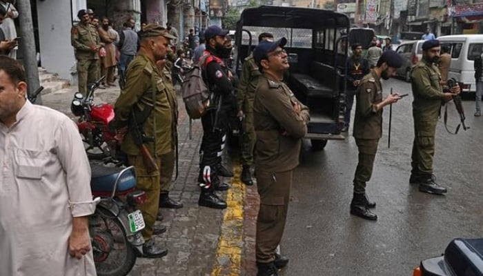 Police personnel patrol a market in Lahore. — APP/File