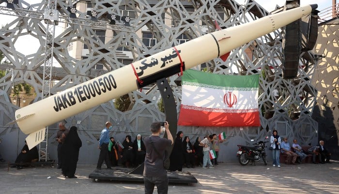 Iranians stand next to a symbol of a Kheibar missile as they take part in a rally in Tehran on June 4, 2026. — AFP