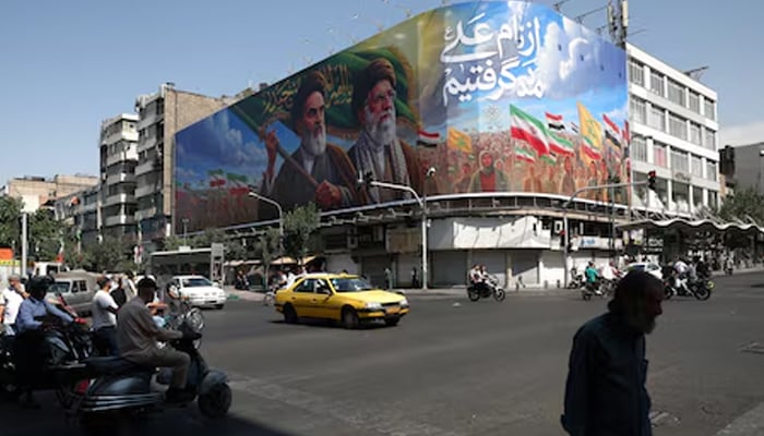People walk past a billboard depicting the late leader of the Islamic Revolution, Ayatollah Ruhollah Khomeini, and the late Irans Supreme Leader Ayatollah Ali Khamenei, on a street in Tehran, Iran, June 10, 2026. — Reuters