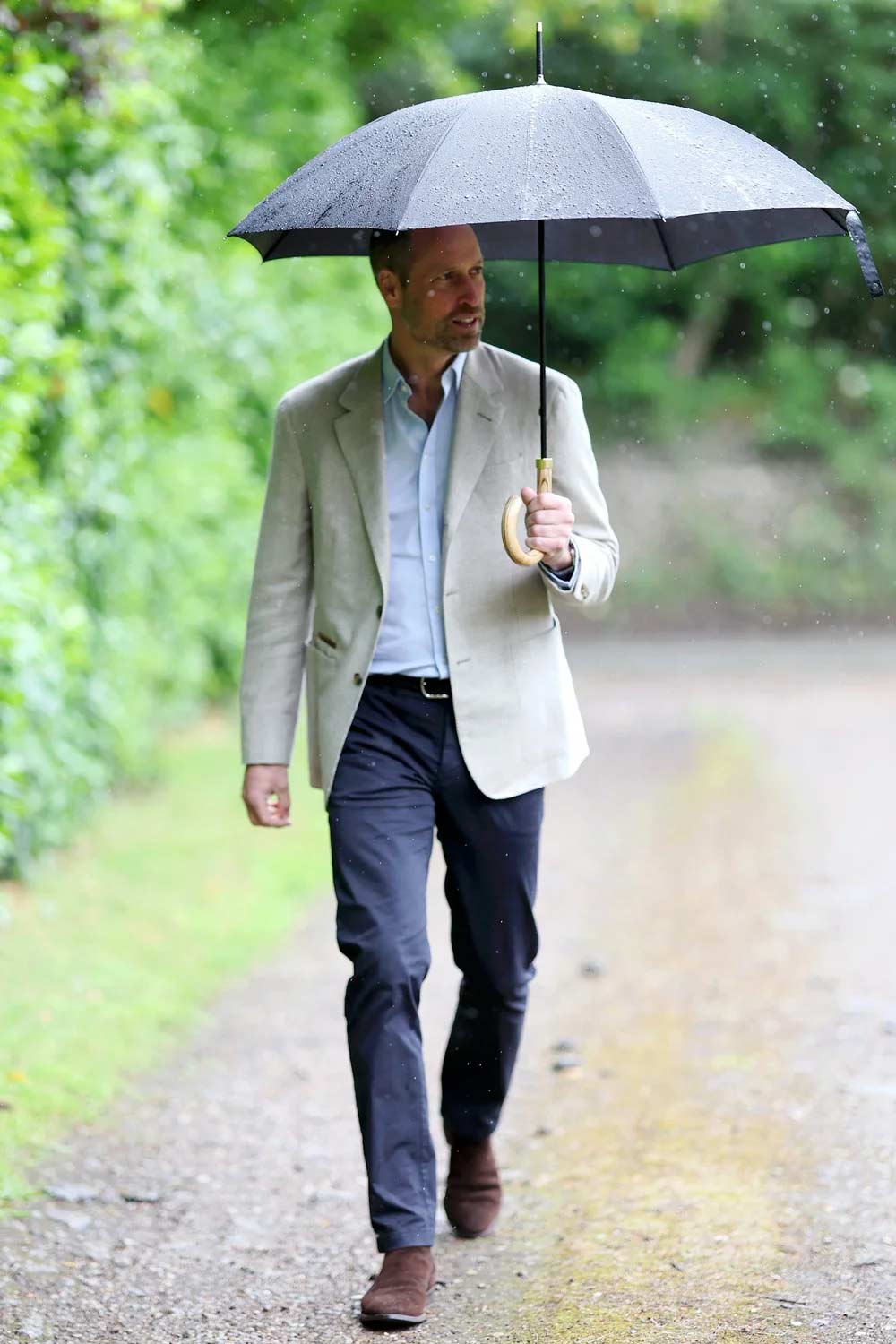 Prince William misses Princess Kate as he braves rain in solo outing