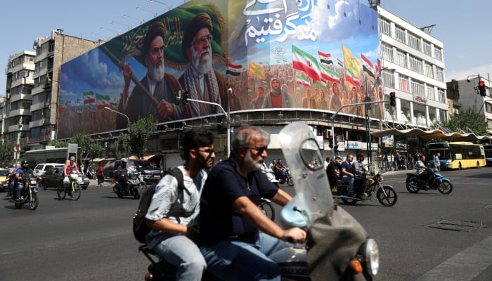 People ride past a billboard depicting the late leader of the Islamic Revolution, Ayatollah Ruhollah Khomeini, and the late Irans Supreme Leader Ayatollah Ali Khamenei, on a street in Tehran, Iran, June 10, 2026. — Reuters