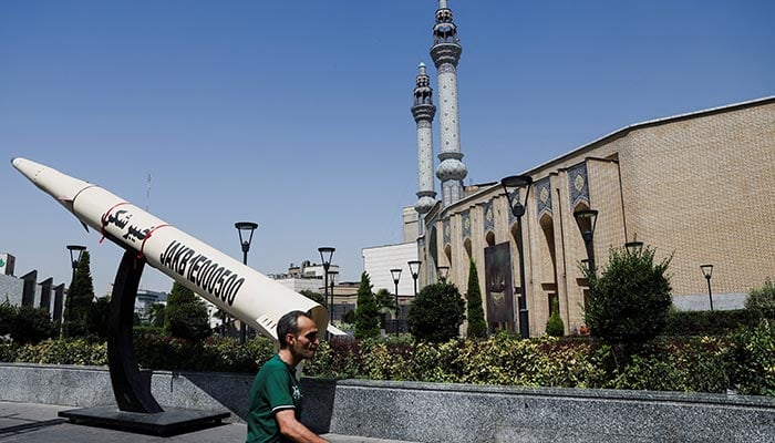 A man walks next to a symbolic mock-up of an Iranian missile, on a street in Tehran, Iran, June 11, 2026. — Reuters