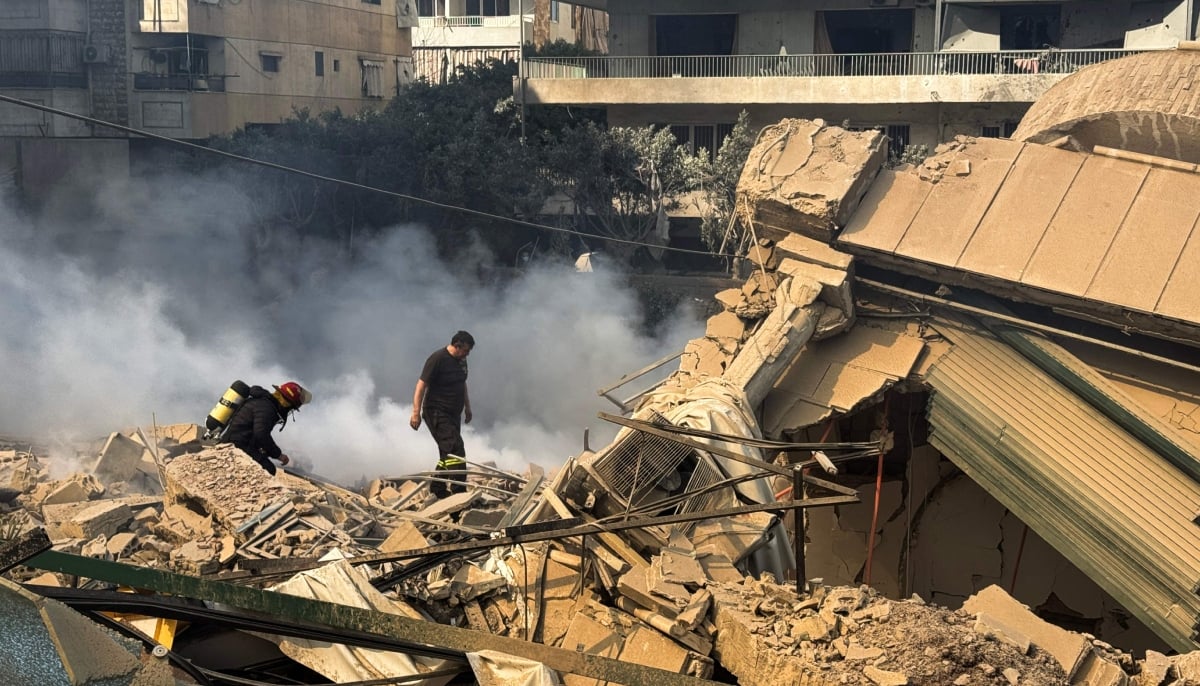 Firefighters inspect destruction at a site of an Israeli airstrike in the southern suburbs of Beirut on March 3, 2026. — AFP