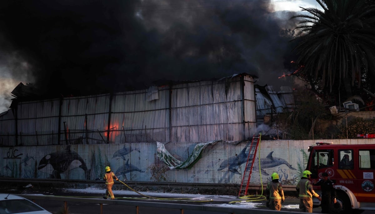 Firefighters extinguish a fire at the site of a strike on the outskirts of Tel Aviv on March 13, 2026. — AFP