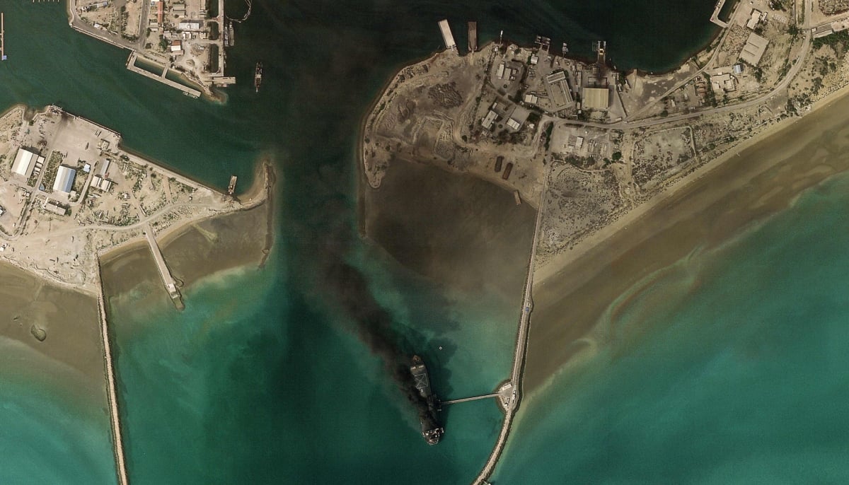 This handout satellite image taken by 2026 Planet Labs PBC on March 2, 2026 shows smoke billowing from a vessel following an explosion from the port of Bandar Abbas along the strait of Hormuz. — AFP