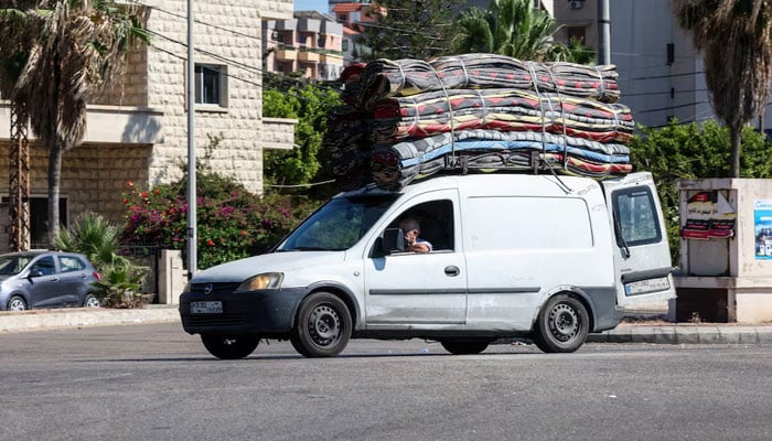A man sits inside a vehicle loaded with belongings, on the outskirts of Sidon, Lebanon, June 19, 2026. — Reuters
