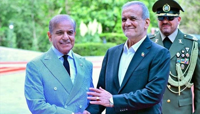 President of Iran Dr Masoud Pezeshkian receives Prime Minister Shehbaz Sharif upon his arrival at Sadabad Palace. — APP/File