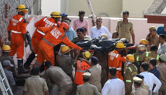 National Disaster Response Force (NDRF) personnel carry the body of a victim, who was killed in a fire that broke out at a coaching centre in Lucknow on June 22, 2026. — AFP