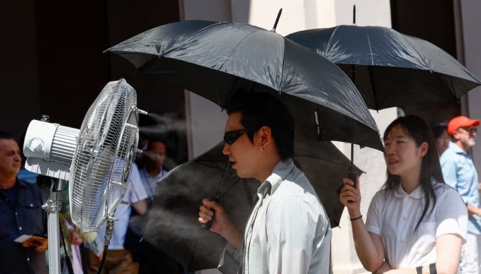 A man stands in front of a cooler spraying water ahead of Thom Browne’s Spring/Summer 2027 men’s collection show as part of Milan Fashion Week, in Milan, Italy, June 22, 2026. — AFP