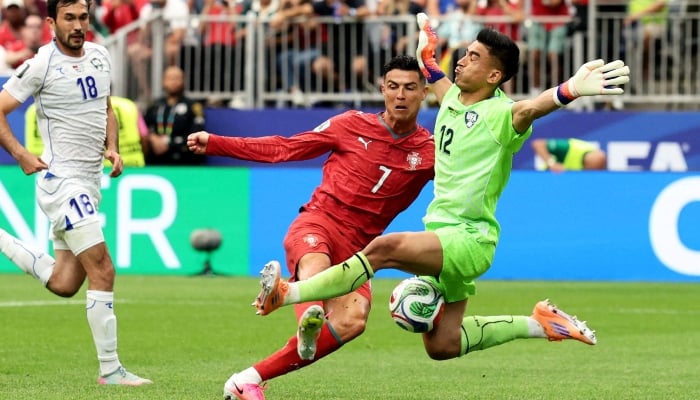 Portugals Cristiano Ronaldo in action with Uzbekistans Abduvohid Nematov. — Reuters