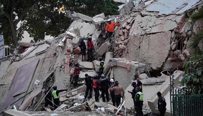 Rescuers search for victims in a collapsed building following an earthquake in Caracas on June 24, 2026.— AFP
