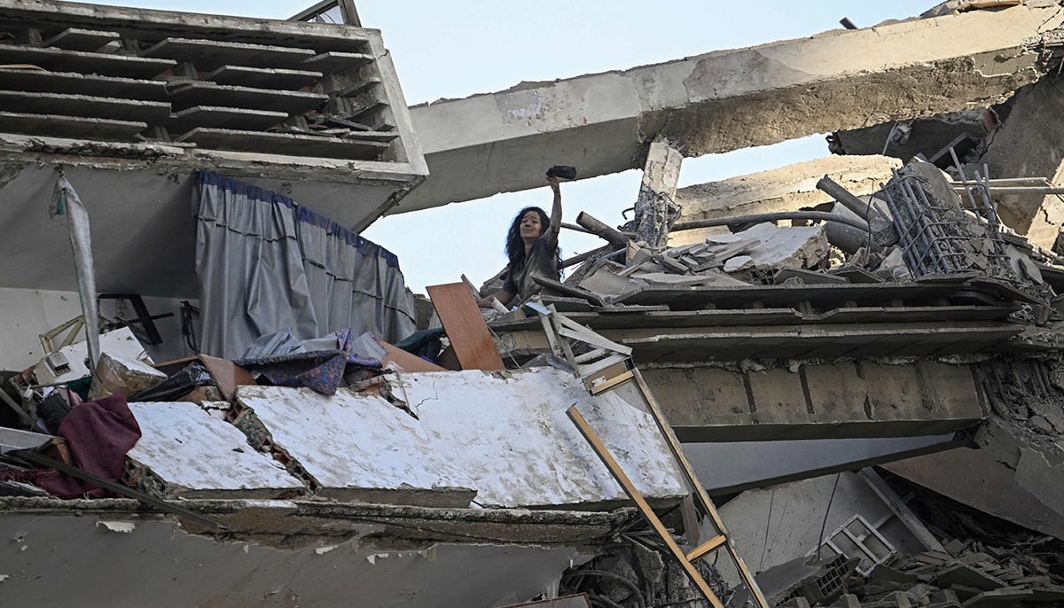 A woman gestures for help atop a damaged apartment building following an earthquake in Catia La Mar, La Guaira state, some 30km north-west of Caracas, on June 25, 2026. — AFP