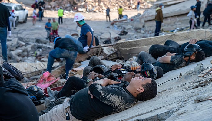 Rescuers and volunteers rest on the rubble of collapsed buildings in Caraballeda, La Guaira state, Venezuela, on June 28, 2026, following earthquakes. — AFP