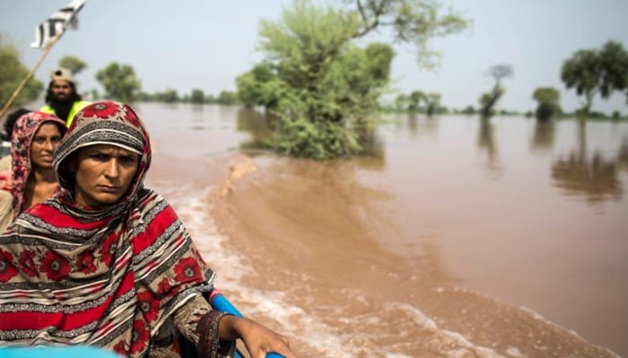 A flood victim sits on a boat while being evacuated from her flooded house following heavy rain in Jhang, Punjab province, September 10, 2014.  — Reuters