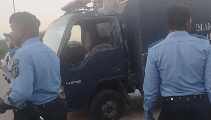 Islamabad police officials standing beside prison van following the armed attack by unidentified assailants at Sangjani Toll Plaza on October 25, 2024. — Geo.tv