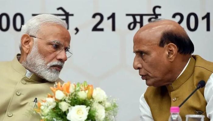 Bharatiya Janata Party (BJP) leader and Defence Minister Rajnath Singh talks with Indian Prime Minister Narendra Modi (L) during an event. — AFP/File