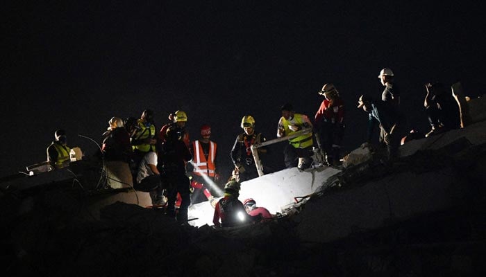 Members of a Mexican rescue team work at the scene of a collapsed building in the Los Corales neighbourhood of Caraballeda, La Guaira State, Venezuela on July 1, 2026. — AFP