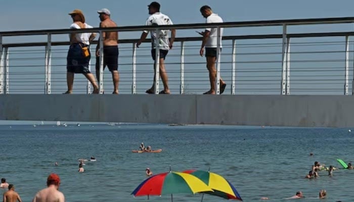 People enjoy at a beach as meteorologists forecast heat and record-breaking temperatures across the country in Timmendorfer Strand, Germany, June 27, 2026.