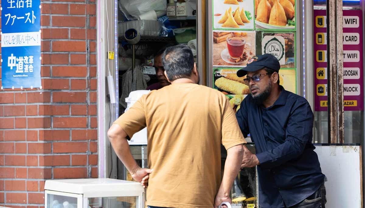 People talk outside of a South Asian restaurant north in the Okubo Shin area in Tokyo on June 12, 2026, a neighbourhood known for its large immigrant communities, including Korean, Southeast Asian and South Asian residents. — AFP