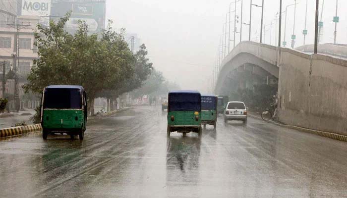 Commuters are passing through the road during the winter seasons downpour at GT road in Peshawar on December 21, 2025. — PPI