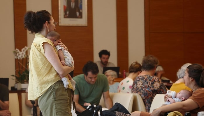 Families with young children gather inside an air-conditioned room open to the public inside the 17th district city hall as temperatures rise in Paris, France, June 25, 2026. — Reuters