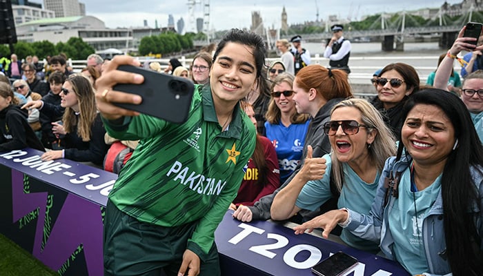 Pakistans team captain Fatima Sana (front L) poses for a selfie with supporters during The Captains Carnival, the activation event for the ICC Womens T20 cricket world cup 2026, in central London on June 7, 2026. — AFP