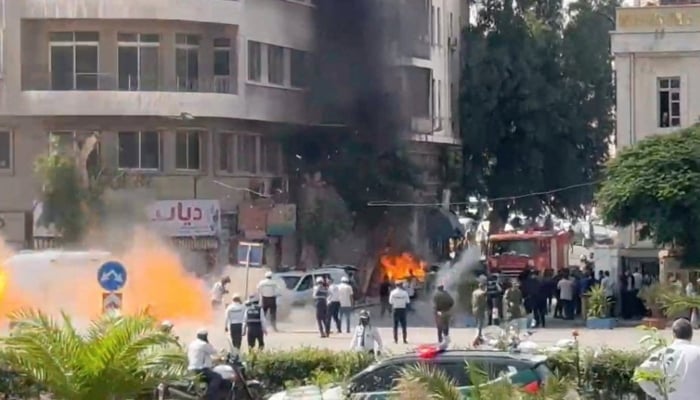 Emergency personnel work as smoke and fire rise at the site where explosive devices blew up near a hotel where French President Emmanuel Macron was meant to be staying, in Damascus, Syria, in this screengrab obtained from a video, July 7, 2026. — Reuters