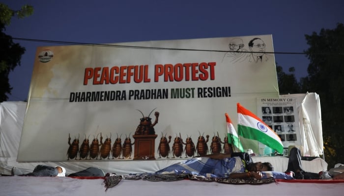 Supporters of the Cockroach Janta Party sleep on a carpet laid on the road during a sit-in protest demanding the resignation of Indias Education Minister Dharmendra Pradhan, at Jantar Mantar in New Delhi, India, June 22, 2026. — Reuters