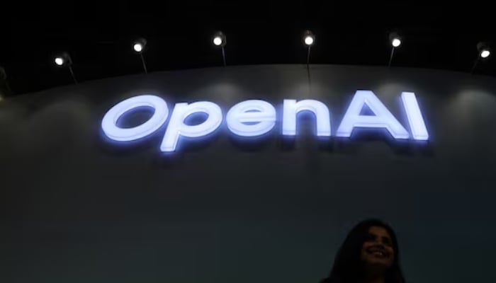 A woman poses for pictures in front of the OpenAI logo at Bharat Mandapam, one of the venues for AI Impact Summit, in New Delhi, India, February 17, 2026. — Reuters