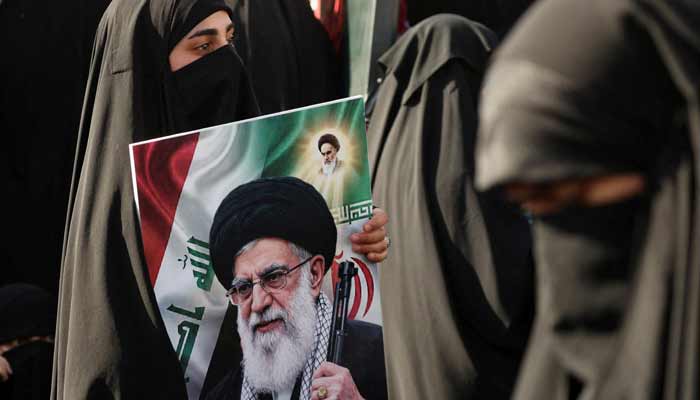 A woman holds a sign featuring a picture of Irans late Supreme Leader Ayatollah Ali Khamenei, during his funeral procession in Najaf, Iraq, July 8, 2026.— Reuters