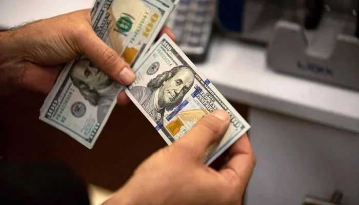 A currency exchange agent counts US Dollars at his company. — AFP/File