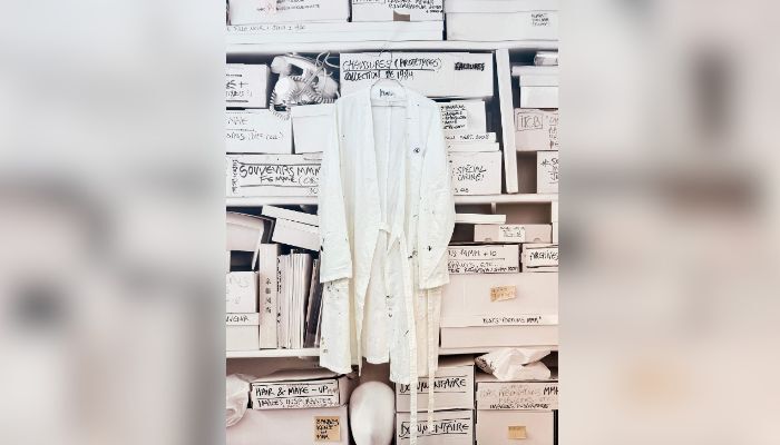This photograph shows Martin Margiela´s personal white coat with his name written inside during an exhibition at the Quartier General in Paris on July 7, 2026. — AFP