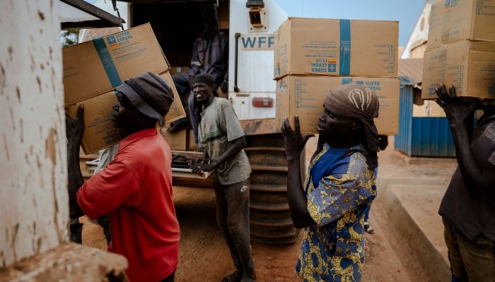 Workers load food commodities onto World Food Programme (WFP) Sherps at the WFP logistics base in Bentiu, Unity State, South Sudan, on November 3, 2025.