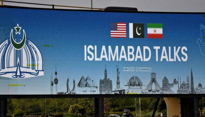 A man rides his motorbike past a billboard installed alongside a road in Islamabad, April 10, 2026. —Reuters