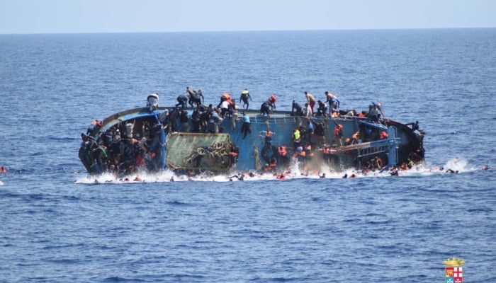 Migrants are seen on a capsizing boat before a rescue operation by Italian navy ships off the coast of Libya in this handout picture May 25, 2016. — Reuters