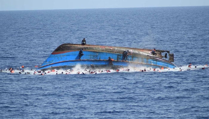 Migrants are seen on a capsizing boat before a rescue operation. — Reuters