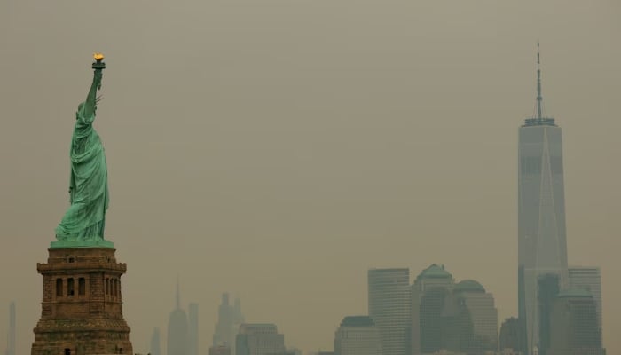The Statue of Liberty in Jersey City, New Jersey, and the One World Trade Centre tower in New York City are seen through a cover of wildfire smoke from New York Harbour, US, July 16, 2026. — Reuters