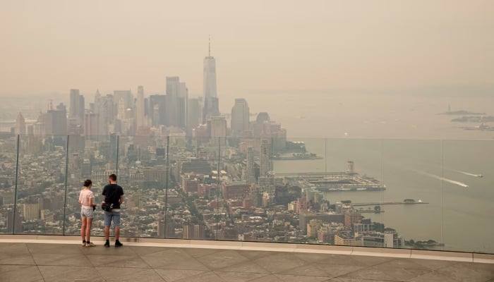 People visit the Edge observation deck as the New York City skyline and One World Trade Centre are seen through a cover of wildfire smoke in New York City, US, July 16, 2026. — Reuters